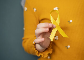 child-holding-yellow-ribbon